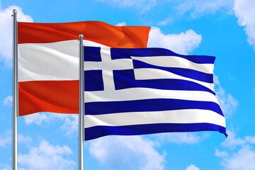 Obraz premium Greece and Austria national flag waving in the windy deep blue sky. Diplomacy and international relations concept.