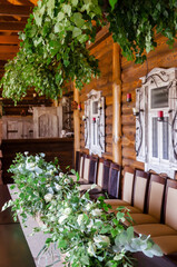 The wedding table is decorated with greenery, served with cutlery. Banquet dinner with a magical gift on a plate