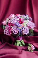 Wedding bridal bouquet on a purple background of roses with the groom's boutonniere