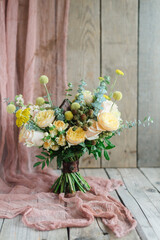 Yellow bouquet with blackberry roses daisy greens on wooden background. March 8 congratulations