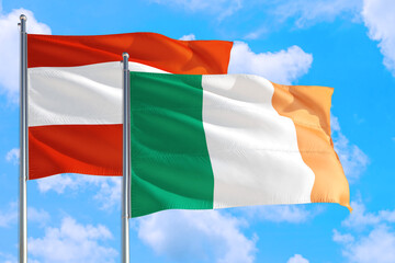 Ireland and Austria national flag waving in the windy deep blue sky. Diplomacy and international...
