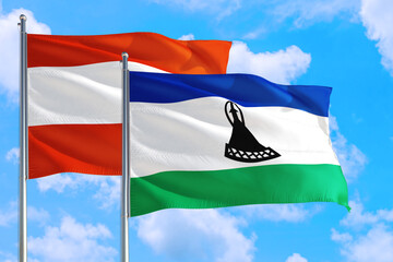 Lesotho and Austria national flag waving in the windy deep blue sky. Diplomacy and international...