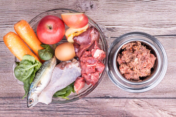 Ingredients of barf raw food recipe for dogs consisting meat, organs, fish, eggs and vegetable