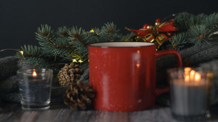 Cacao mug, christmas background with candles and pine cones on christmas tree branch
