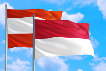 Monaco and Austria national flag waving in the windy deep blue sky. Diplomacy and international relations concept.