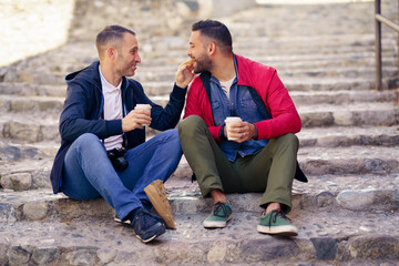 Gay couple having a take-out meal on the street