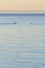 Fototapeta na wymiar Morning swim at Cala Azzurra, Favignana, Italy. Nice warm sunrise colors in a summer day