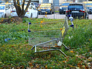 Abandoned in the grass metal trolley from the supermarket