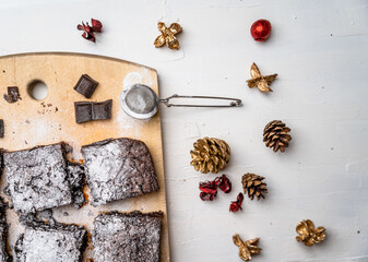 Overhead shot of freshly baked brownies with rustic colorful Christmas decors on white table
