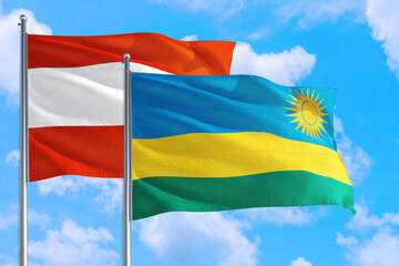 Rwanda and Austria national flag waving in the windy deep blue sky. Diplomacy and international relations concept.