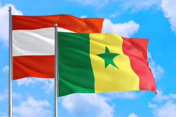 Fototapeta na wymiar Senegal and Austria national flag waving in the windy deep blue sky. Diplomacy and international relations concept.