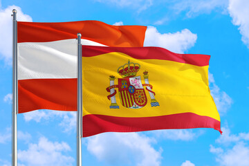 Spain and Austria national flag waving in the windy deep blue sky. Diplomacy and international relations concept.