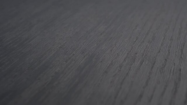 Painted wooden black texture close up. Rotation. Dark gray abstract background. Eco material