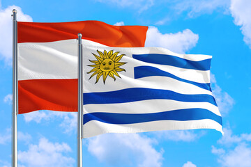 Uruguay and Austria national flag waving in the windy deep blue sky. Diplomacy and international relations concept.