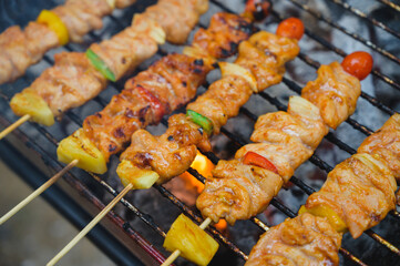 Barbecue cooking over a hot fire with assorted spicy chicken on the grill