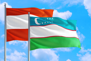 Uzbekistan and Austria national flag waving in the windy deep blue sky. Diplomacy and international relations concept.