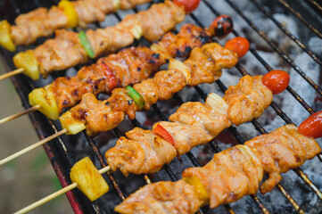 Barbecue cooking over a hot fire with assorted spicy chicken on the grill