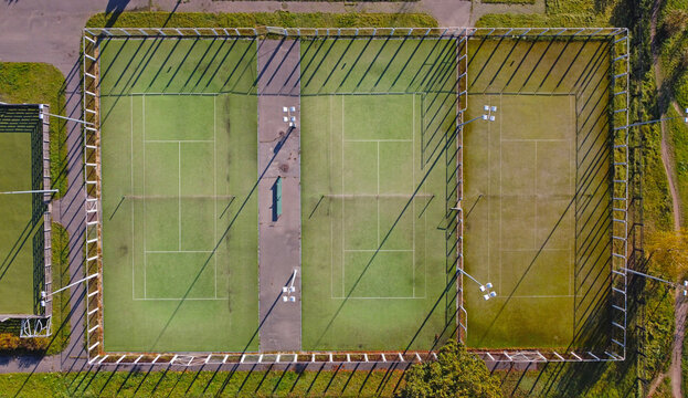 Top view of empty tennis courts with green lawn
