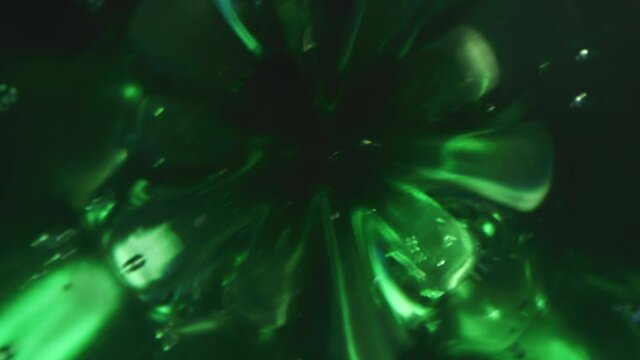 Probe lens dolly macro shot inside a green plastic bottle of carbonated water