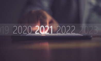 Business men press numbers 2021 at the mobile phone screen .Concept welcome merry christmas and...