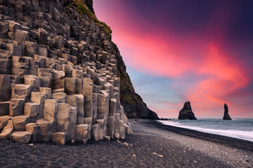 Incredible view on Black beach and Troll toes cliffs in sunset time. Great purple sky glowing on...
