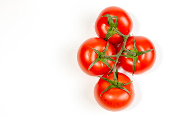 Close-up of red juicy tomatoes on one branch. View from above