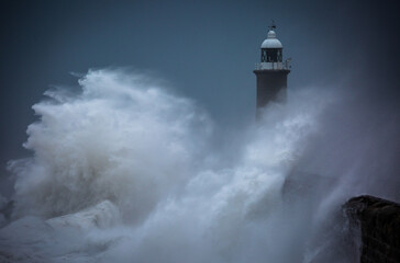 Giant waves batter the lighthouse & north pier guarding the mouth of the Tyne in Tynemouth, England