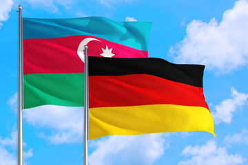 Germany and Azerbaijan national flag waving in the windy deep blue sky. Diplomacy and international relations concept.