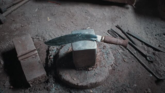 Traditional Nepalese kukri knife placed decoratively on a square anvil