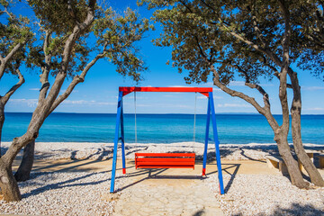 Swing on the shore between pine trees of the island of Pag in Croatia on Adriatic sea