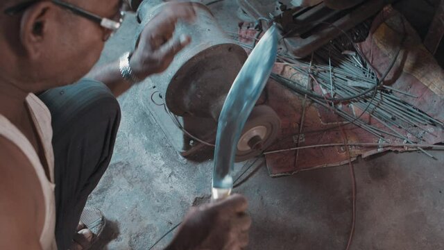 Man sharpening a large metal knife on a machine