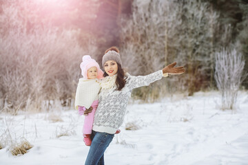 Obraz premium Happy family playing and laughing in winter outdoors in the snow. City park winter day.