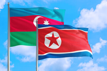 North Korea and Azerbaijan national flag waving in the windy deep blue sky. Diplomacy and international relations concept.
