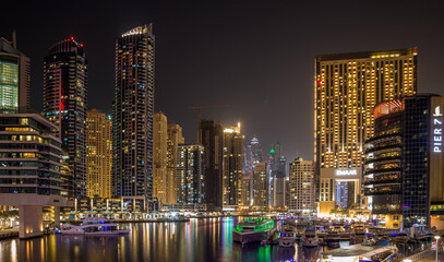 Fototapeta na wymiar Dubai Marina at night, with all the lights from buildings and the boats making for a beautiful scene