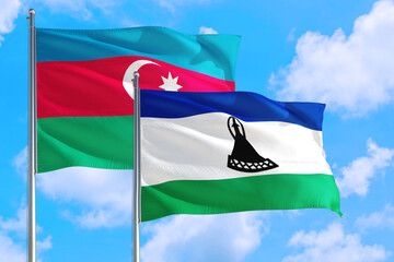 Lesotho and Azerbaijan national flag waving in the windy deep blue sky. Diplomacy and international relations concept.