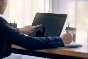 Close up of businesswoman hand pointing at her laptop