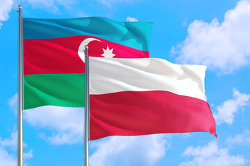 Poland and Azerbaijan national flag waving in the windy deep blue sky. Diplomacy and international relations concept.