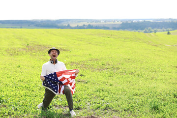 Man waving American flag standing in grass farm agricultural field , holidays, patriotism, pride, freedom, political parties, immigrant