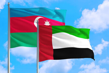 Fototapeta na wymiar United Arab Emirates and Azerbaijan national flag waving in the windy deep blue sky. Diplomacy and international relations concept.