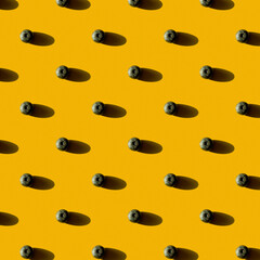 Blueberry pattern on yellow background. Flat lay, top view. Minimalistic concept. 