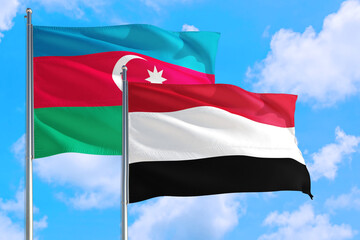 Fototapeta na wymiar Yemen and Azerbaijan national flag waving in the windy deep blue sky. Diplomacy and international relations concept.
