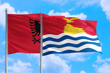 Kiribati and Albania national flag waving in the windy deep blue sky. Diplomacy and international relations concept.