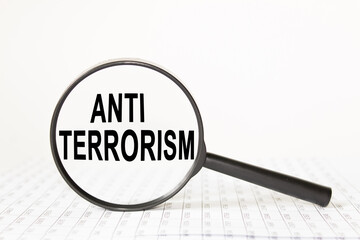 words ANTI TERRORISM in a magnifying glass on a white background. business concept