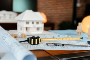 Measure tape, calculate,  safety helmet, book on house blue print. Engineering, plaining, drafting  tool and equipment concept.
