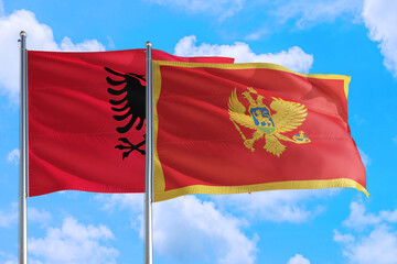 Montenegro and Albania national flag waving in the windy deep blue sky. Diplomacy and international relations concept.