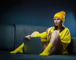 woman on sofa with laptop eating sexy banana