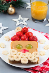 Santa sandwich made from toast, peanut butter, strawberry, banana, grape and apple, Christmas menu, vertical