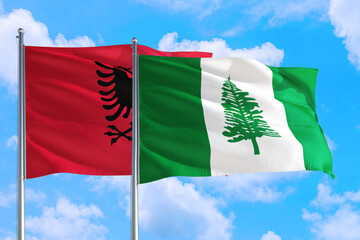 Norfolk Island and Albania national flag waving in the windy deep blue sky. Diplomacy and international relations concept.