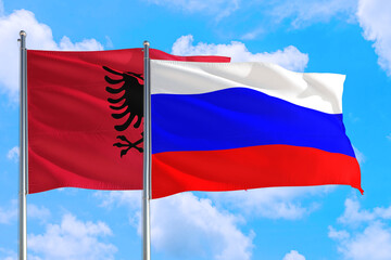 Russia and Albania national flag waving in the windy deep blue sky. Diplomacy and international relations concept.