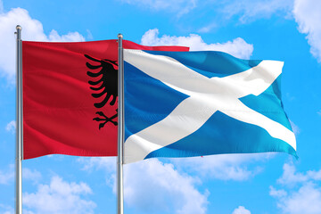 Scotland and Albania national flag waving in the windy deep blue sky. Diplomacy and international relations concept.